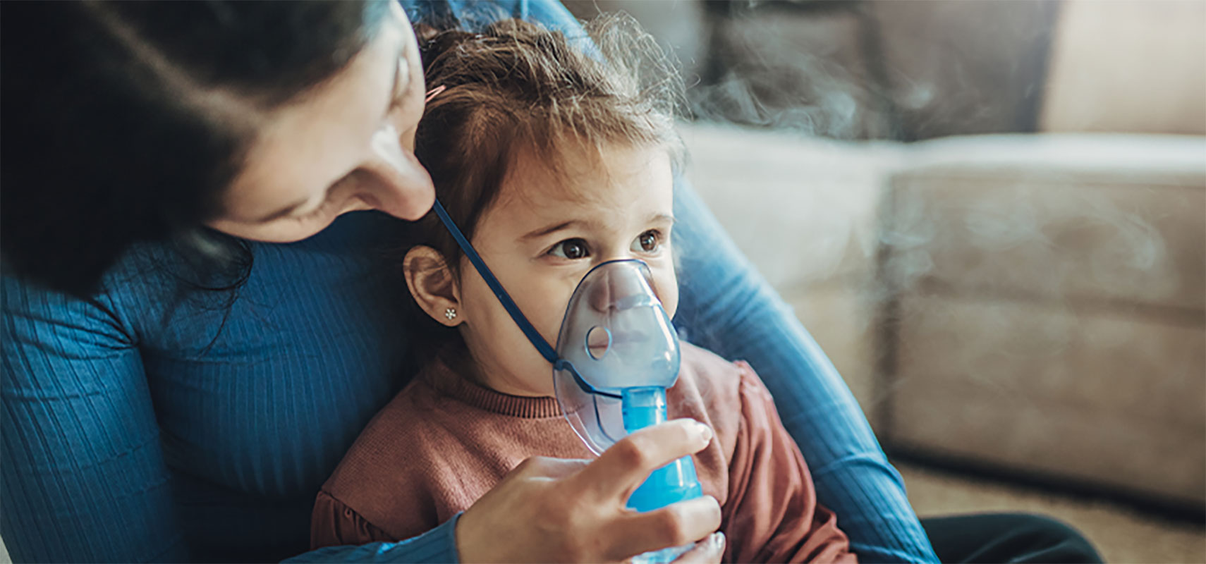 Mother with her daughter using an inhaler.