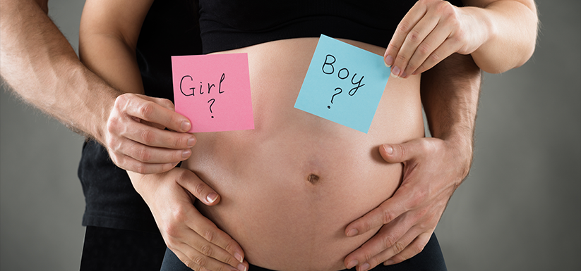 Young couple expecting with a close-up on their mid section.