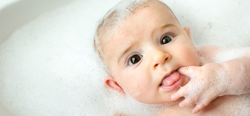Newborn baby having a bubble bath.