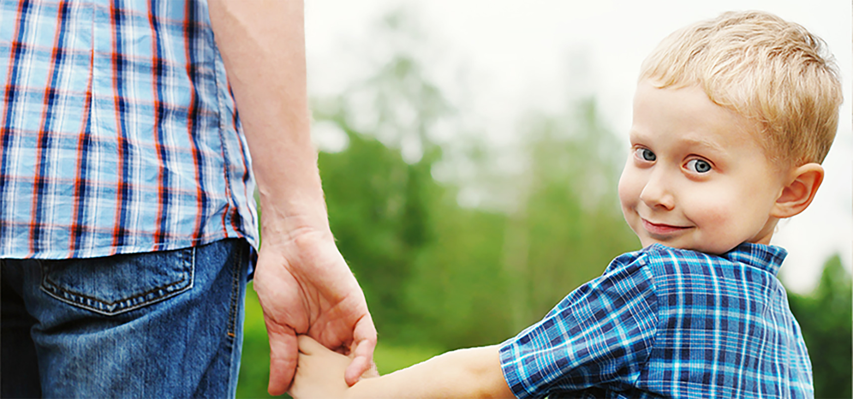 Little boy holding hand with father.