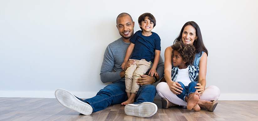 Happy multi-ethnic family sitting together on floor.