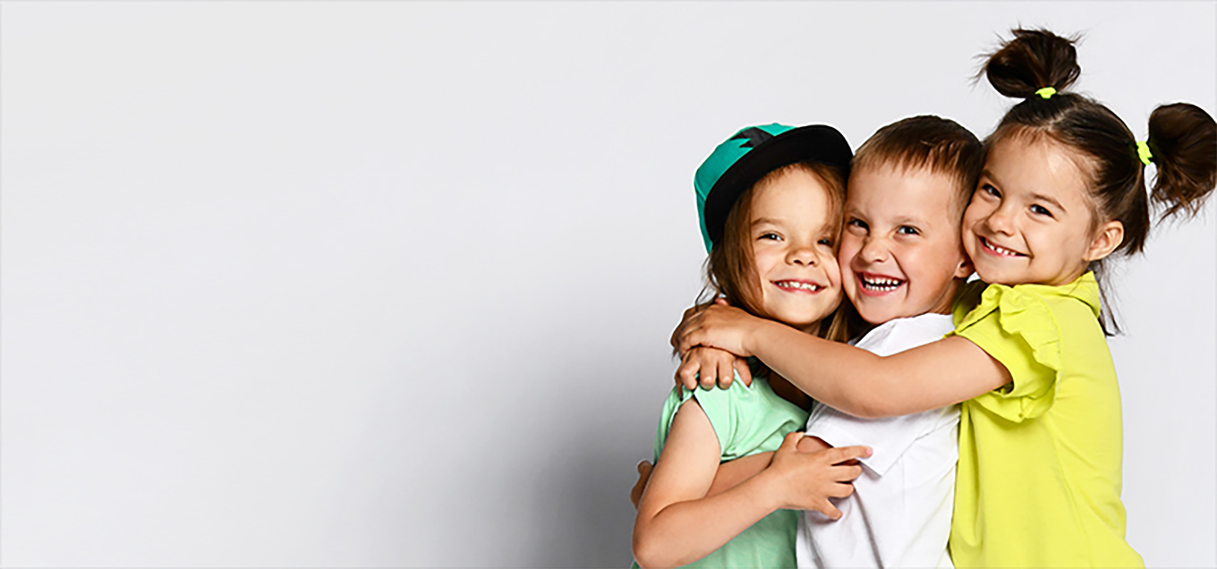 A group of children smiling and hugging.